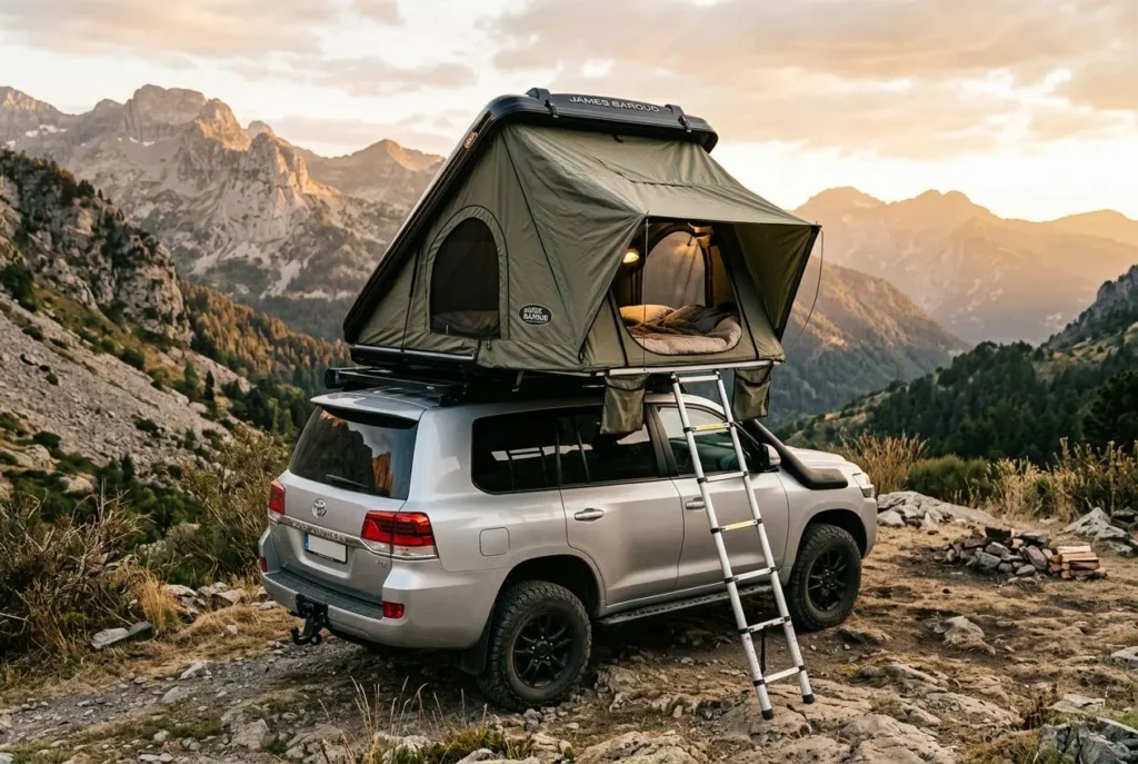 Tente de toit James Baroud installée sur un SUV en montagne au coucher du soleil, avec échelle et intérieur visible. tente de toit james baroud guide complet intégré naturellement.