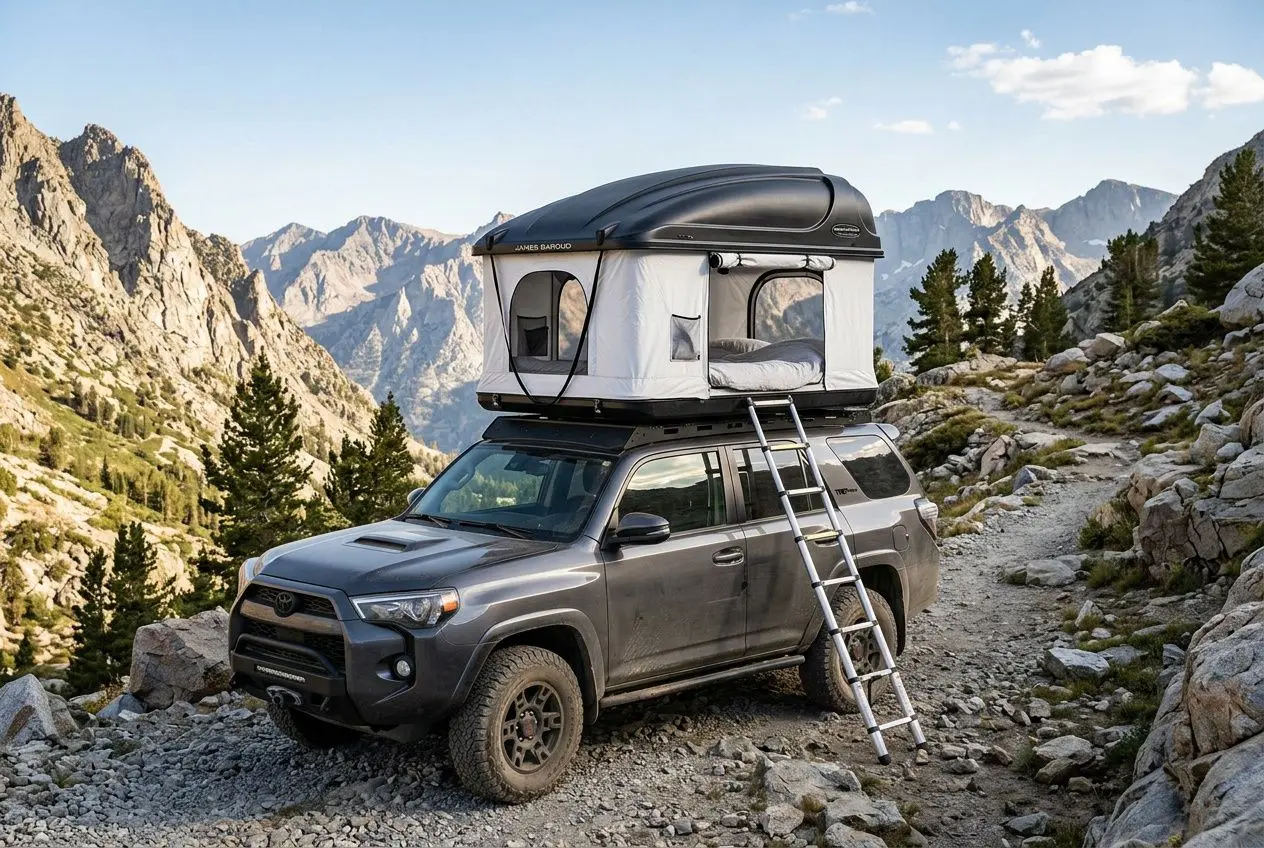 Tente de toit James Baroud Odyssey M montée sur un SUV gris dans un paysage montagneux rocky, échelle et ouverture guidée visibles.